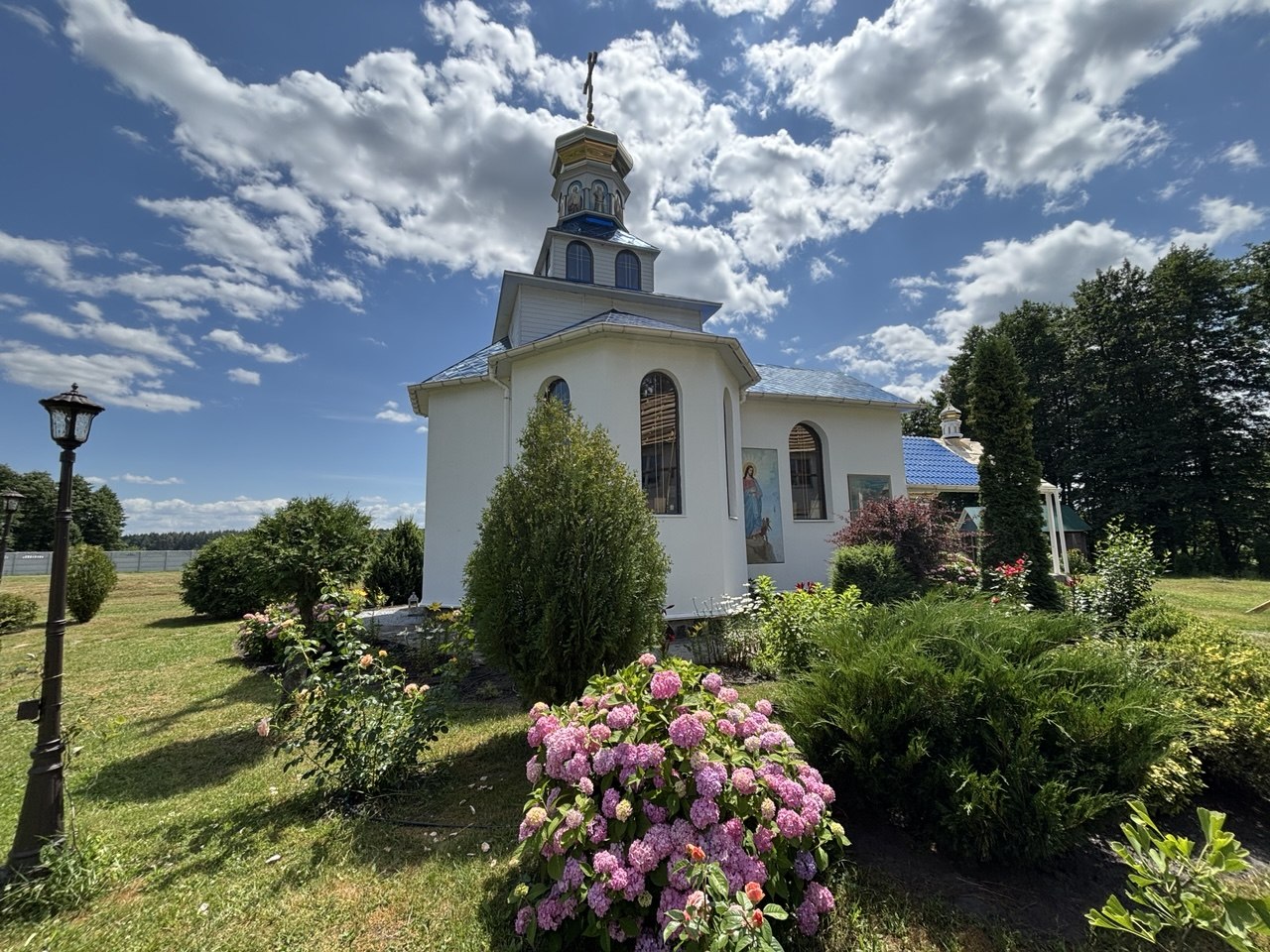 Храм скиту у Соболівці серед квітів і літнього неба